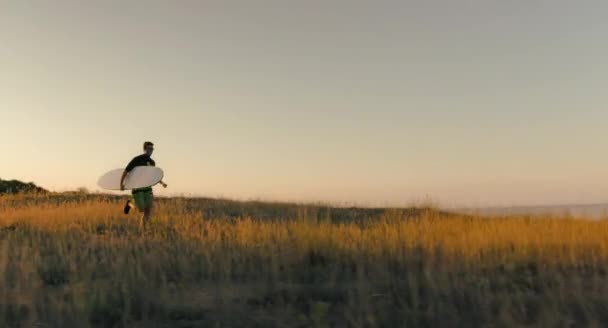 Szörfös fut a strandon — Stock videók