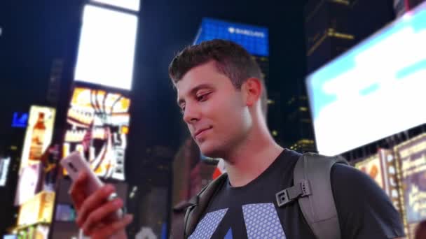 Mladý muž, textových zpráv v New York City, na Times Square — Stock video