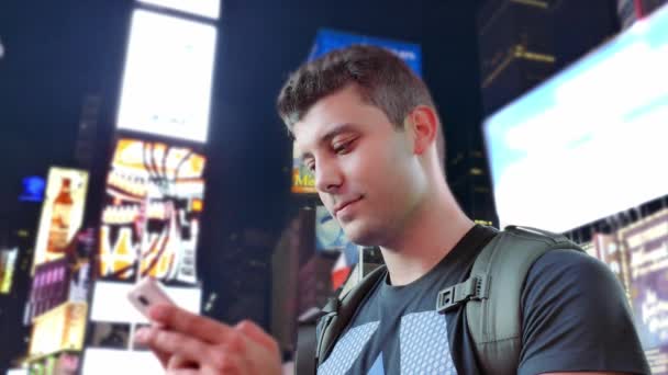 Mladý muž, textových zpráv v New York City, na Times Square — Stock video