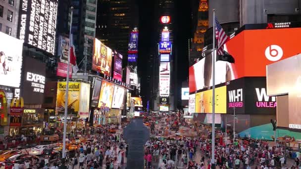 Turistler reklam ışıkları altında yürürken Şehir binaları ve kalabalık gece Times Meydanı'nda. — Stok video