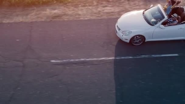 Vuelo aéreo sobre una joven pareja en vacaciones de verano conduciendo un coche convertible Cabriolet en el océano frente a la carretera Verano Diversión Vacaciones Libertad Concepto — Vídeo de stock