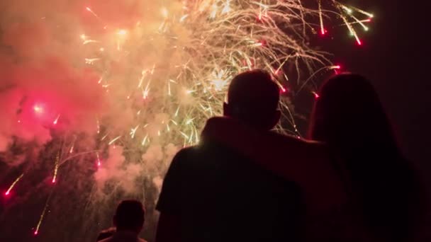 Hermosos fuegos artificiales como hombre y mujer Hogging siluetas en la víspera de Año Nuevo Romántico relación concepto de familia — Vídeos de Stock