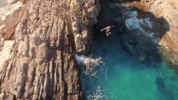 健壮的年轻男人，离海边的悬崖上跳入美丽的蓝色水极端体育休闲度假体育概念 — 图库视频影像