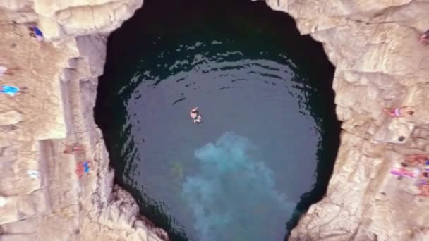 Mouvement Lent De L'homme Sautant Dans La Piscine Naturelle D'eau Bleue De Falaises Rochers Vue Aérienne Eau Bleue Belle Île Vacances Concept De Sport Extrême — Video