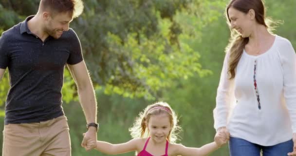 Aile sıcaklığı, anne-baba ve çocuk parkta yürürken ve oynarken, karı-koca ve çocuğun mutluluğu kırmızı destansı 8K 'da yavaş çekim kavramına dayanır. — Stok video