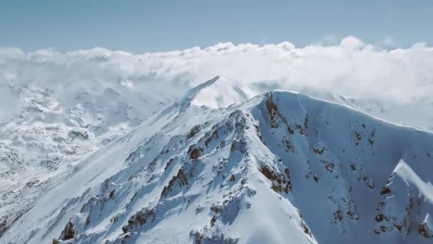 Vôo aéreo do drone sobre a escala da montanha da neve com mar das nuvens Férias frias européias do inverno GodS View 4k Slow Motion — Vídeo de Stock