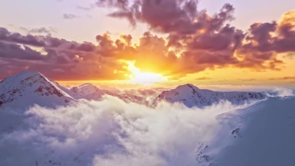 Latanie przez chmury nad szczytami gór Raj Niebo Wieczność Stworzenie pasmo górskie Zima Śnieg Zimny zachód słońca Złoty Hour Wysokie szczyty Wspaniały Inspirujący Krajobraz Naturalny 4K — Wideo stockowe