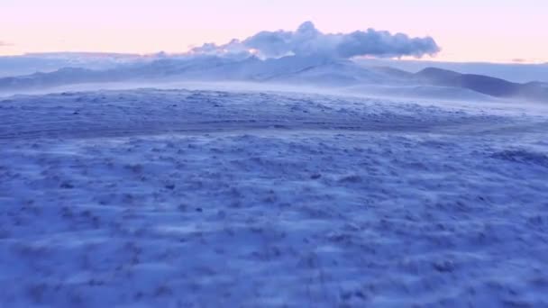 Dağ tepelerinde kar yağışı üzerine uçuş. Altın saat. Renkli Mor Turuncu Gökyüzü. — Stok video