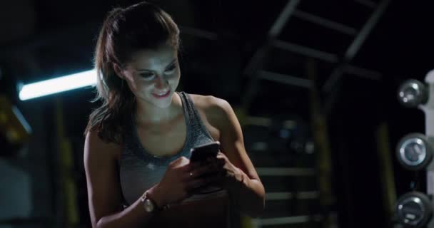 健康运动女子手持智能电话发短信健身中心积极生活方式休闲健身技术概念4k — 图库视频影像