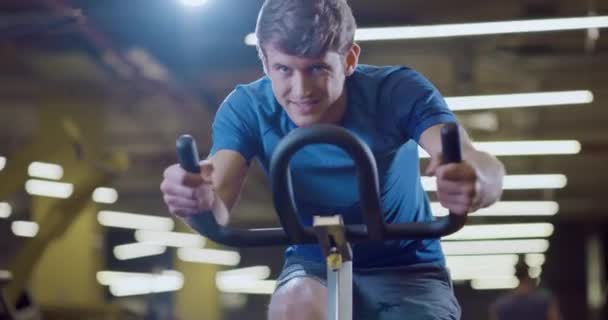 Odhodlaný mladý muž Sportsman Fitness cvičení na stacionárním kole fitness centrum zdravý život perzistence Zdraví Zaostřený Fitness koncepce 4k — Stock video