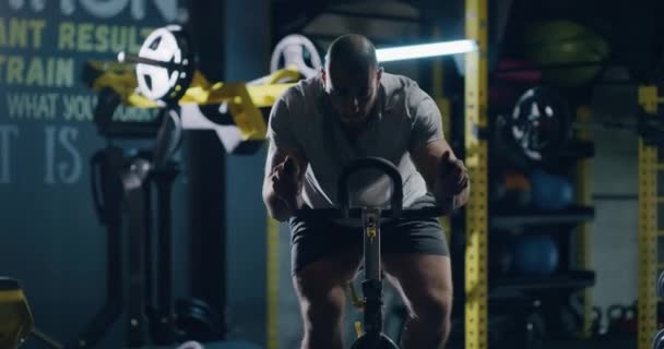Caucasion Muskulös Män Idrottare Träna på stationär cykel inomhus Aktiv livsstil Sportsvanar Bestämning Utmaning Hälsa Fokuserad Fitness Concept 4k — Stockvideo