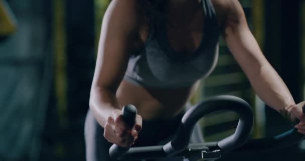 Hermosa mujer atlética haciendo ejercicio en bicicleta estacionaria de cerca en el gimnasio Estilo de vida activo Ropa de deporte Persistencia Salud Centrado Concepto Fitness 4k — Vídeos de Stock