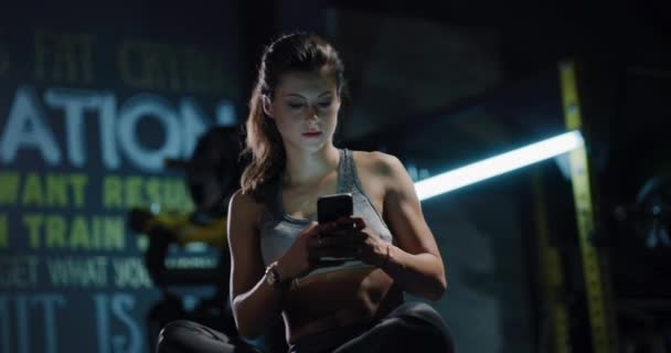 Young Fit Woman In Sportswear Att ha en paus Kontrollera sociala nätverk på gymmet Aktiv livsstil Avslappning Fitness Technology Concept 4k — Stockvideo