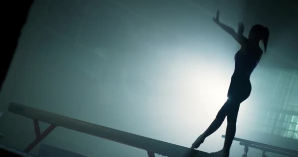 体操健美生活方式中迷人的女运动员在平衡木上做卡特轮竞技健美操思维定势概念4k — 图库视频影像