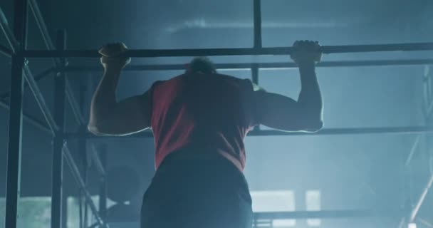 Silny muskularny mężczyzna atleta Wykonywanie pull upps On Horizontal Bar Indoors Trening funkcjonalny Trwałość Crossfit Focus Success Concept 4k — Wideo stockowe