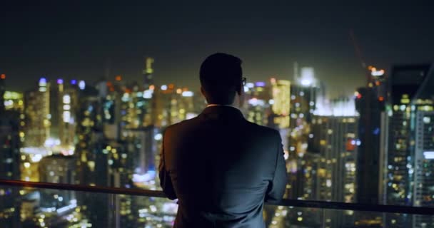 Giovane uomo d'affari guardando città Sky Scrapers paesaggio urbano Imprenditorialità Luci notturne urbane rallentatore rosso epico 8k — Video Stock