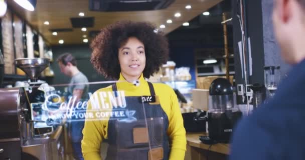 コーヒーショップでのアフリカの若い女性バリスタサービスの顧客未来的な技術ディスプレイとの相互作用将来の支払い方法コンセプトスローモーションレッドエピック8K — ストック動画