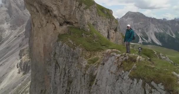Joven hombre de pie en la cima de un pico de montaña en los Alpes italianos vacaciones extremas felicidad vuelo aéreo drone — Vídeos de Stock