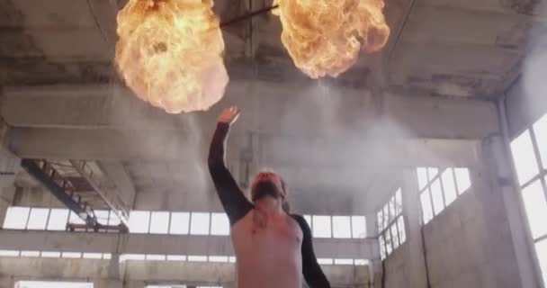 Spinner di fuoco maschile che esegue spettacolo di fuoco in edificio abbandonato pericolosa acrobazia professionale Nebbia rallentatore 8k rosso epica — Video Stock