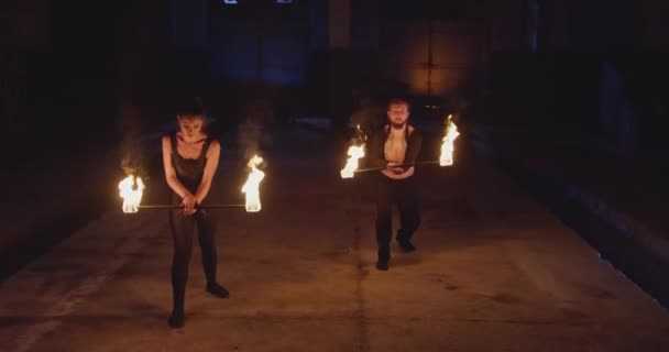 Kaskader Mężczyzna i kobieta wykonują pokaz ognia w ciemności igrając z ogniem Mgła słabe światło Slow Motion 8k Red Epic — Wideo stockowe