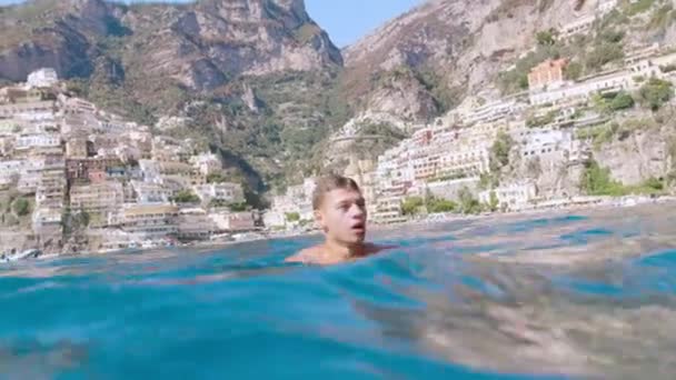 Junger Mann schwimmt im Ozean am Holliday in Italien Reise Abenteuer Urlaub Abenteuer Konzept Shot Red Epic 8k — Stockvideo