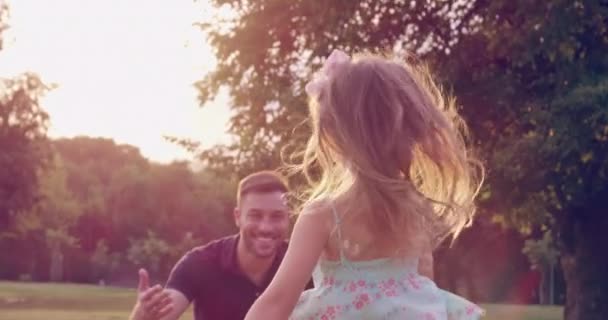 在夕阳西下，小女孩跑着拥抱她的父亲在公园里，家人爱着幸福孩子的概念慢慢地，慢慢地，慢慢地，在红色的史诗中，8K — 图库视频影像