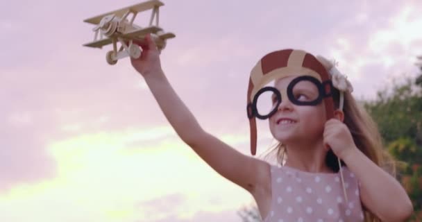 Menina bonito criança brincando com avião brinquedo no parque ao pôr do sol Golden Hour infantil inocência jogar conceito lento movimento tiro no épico vermelho 8K — Vídeo de Stock