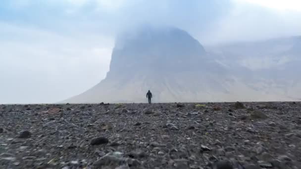 Letecký let směrem k Man Walking na Islandu Nordic Mountain Landscape Fog Rain Young Earth Environment Epic Scale Confidence Dacing Problems Loneliness Depression Conept — Stock video
