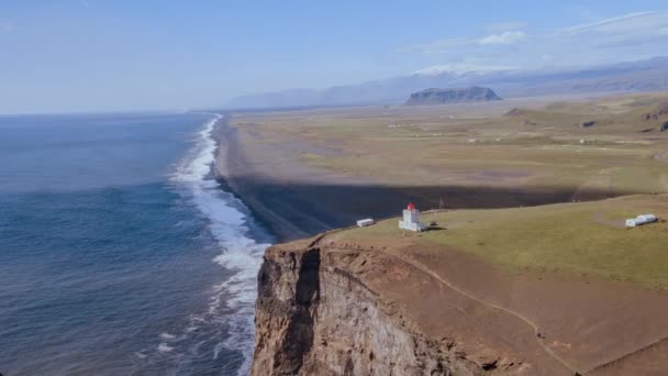 Vuelo aéreo del dron sobre la casa de la luz del acantilado en la orilla Islandia Arena negra Naturaleza Belleza Aventura Viajes — Vídeo de stock