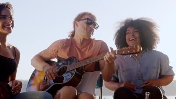 Attractive Multiracial Group Of Young Friends Sitting Around Bonfire In Forest Singing Along To Guitar Laughing And Clapping Along Music And Camping In Nature Travel Party Concept Slow Motion Shot On — Stock Video