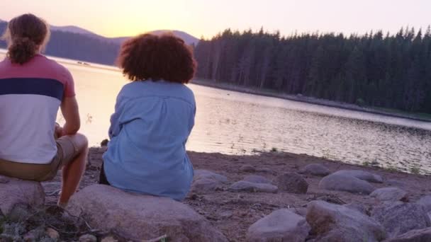 Groupe d'amis heureux assis et riant sur la rive du lac Aventure frémissante dans les bois Young Love Concept Slow Motion Shot sur Red Epic W 8k — Video