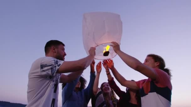 Happy Young Grupo de amigos lanzando Sky Lantern en Lake Shore al anochecer Sonriendo Amistad y turismo Disparo en cámara lenta en Red Epic W 8k — Vídeos de Stock