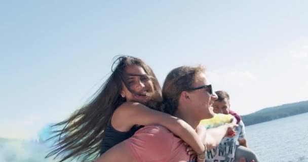 Привабливе молоде щасливе подружжя, що крутиться і сміється на пляжі озера, проходить крізь хмари диму романтичну природу, радісне сімейне поняття повільного руху, знятого на червоному епосі w 8k — стокове відео