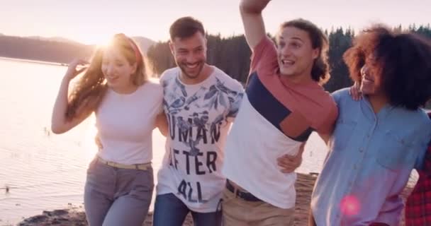 Groep van gelukkige vrienden omhelzen en lachen tijdens een wandeling aan het meer socialiseren vakantie in de natuur geluk in de natuur concept slow motion schot op rode epische w 8k. — Stockvideo