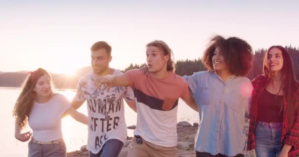 Grupa szczęśliwych przyjaciół przytulić i spacerować po brzegu jeziora wav ręce przyjaźń i szczęście w dzikim szczęściu w koncepcji przyrody slow motion shot on red epic w 8k. — Wideo stockowe