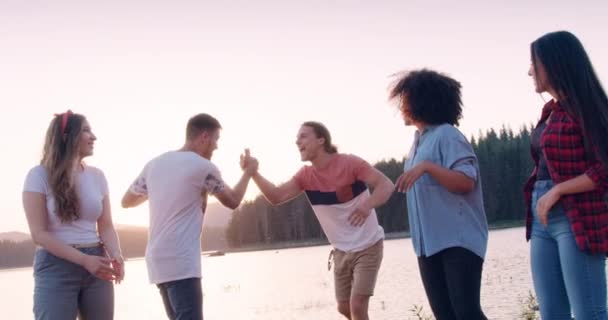 Happy young group of friends walk and laugh on lake shore wav hands adventure in the woods romantic getaway concept slow motion shot on red epic w 8k. — Stock Video