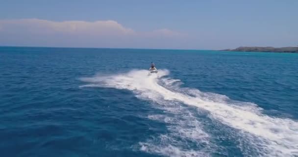 Aerial Drone Strzał przechodzący nad człowiekiem Prędkość na skuterze wodnym na tropikalnej plaży Ocean Island w Zakynthos Wyspa Zante wakacje Plaża Sport Lato Podróże Atrakcje turystyczne Przygody Pojęcie przygody Słońce świeci — Wideo stockowe