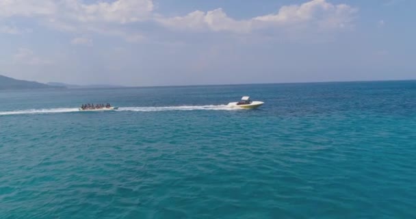 Aerial Shot View Over People Speeding On Jet Ski Banana Boat Atração turística Ilha tropical exótica Praia Férias Praia Esportes Férias Turismo Aventura Conceito — Vídeo de Stock