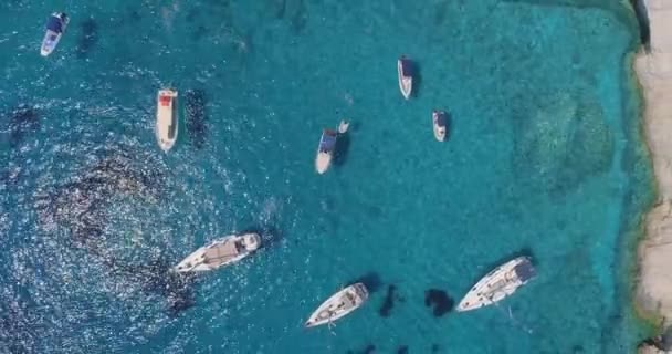 Aerial Drone Shot passing Over Tourist Boats and Yachts at Rocky Tropical Ocean Island Shore Famous Zante Island Tourist Summer Travel Concept On Hot Summer Day — 비디오