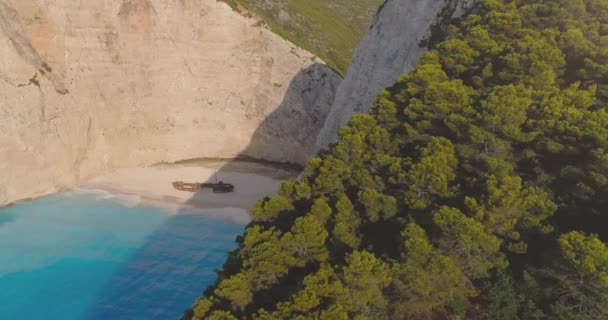 Aerial Drone Shot Pasando por los altos acantilados del océano y Forrest Famoso hito Naufragio Playa Fotografía Aérea Turismo Paraíso Concepto Con Lente Flare — Vídeos de Stock