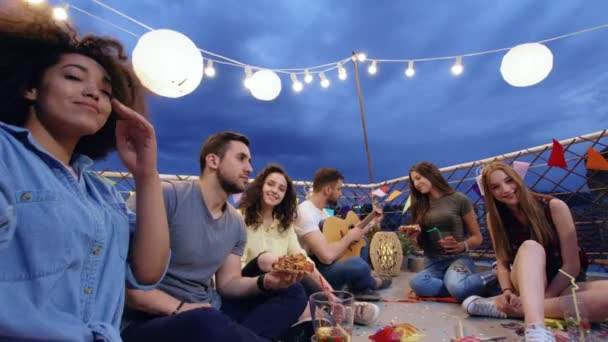 Erkekler gitar çalarken ve arkadaşlar ritm içinde dans ederken, kokteyller içerken ve açık havada pizza yerken, neşeli müzik partileri yaparken ve tasasız pizza partileri yaparken, — Stok video