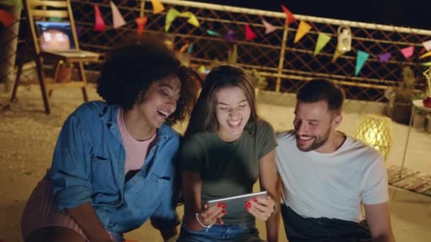 Diversos jovens amigos do partido no telhado olhando para um tablet sorrindo e compartilhando vídeos engraçados da Internet olhando para um projeto juntos Trabalho em equipe Tempo de diversão com tecnologia na festa 3g 4g 5g Futuro — Vídeo de Stock