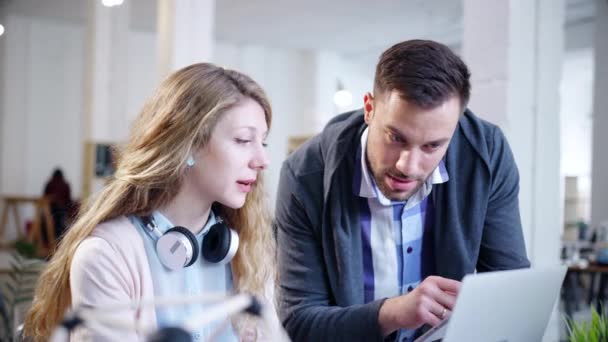 Compañeros de trabajo jóvenes de moda mirando a un ordenador portátil discutiendo nuevas ideas Desarrollando el éxito de la nueva tecnología de cámara lenta 4K tiro en rojo épica 8K — Vídeos de Stock