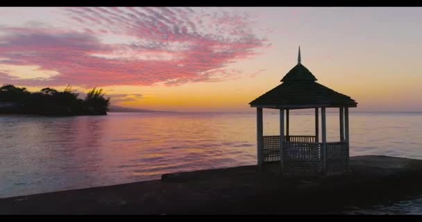 Drona aeriană împușcat peste romantic Jetty Pier Blue Ocean și tropical Beach Apus de soare Jamaica Scenic Seascape Tropical Turism de vacanță și Concept de călătorie la Golden Hour Dusk Slow Motion 4k — Videoclip de stoc