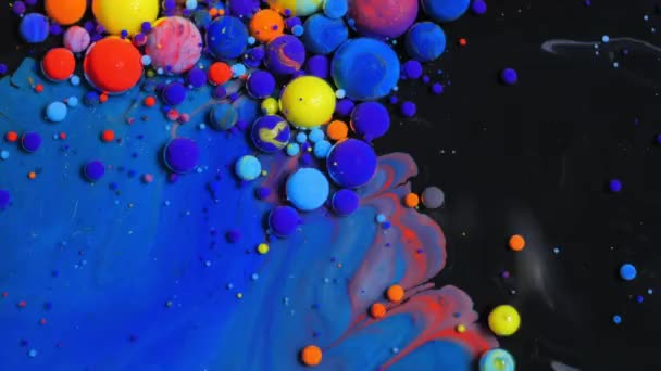 Мультикольорові бульбашки яскравих колекцій, що рухаються в яскравій олійній поверхні красивий блакитний всесвіт кольорового повільного руху Макро-червоний синій і жовтий. — стокове відео