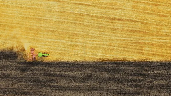 Luftaufnahmen Landwirtschaft Autonomer Traktor Pflügt Feld Mit Schöner Staubsäule Hinter Stockbild