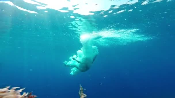 Jovem saltando para a água subaquática tiro ondulações ativo atlético aventura tropical praia penhascos azul abismo respingo férias férias praia Gopro HD — Vídeo de Stock