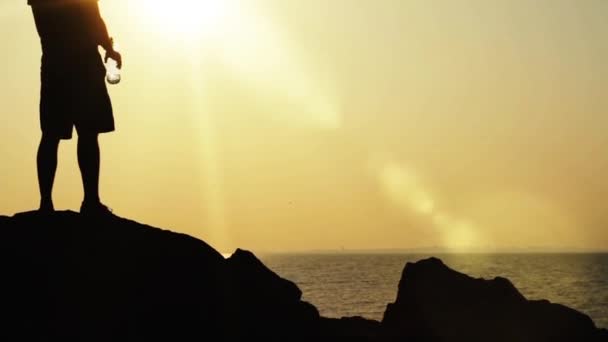 Viagem silhueta escalador rochas pôr do sol mar sede conceito HD — Vídeo de Stock