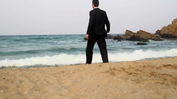 Hombre de negocios saltando en la playa de agua espera concepto de vacaciones — Vídeos de Stock