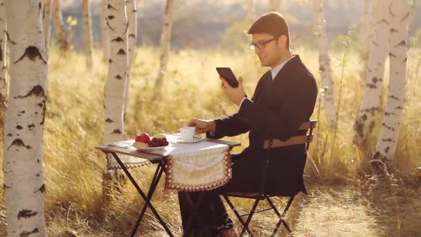 Бизнесмен за завтраком читает планшет — стоковое видео